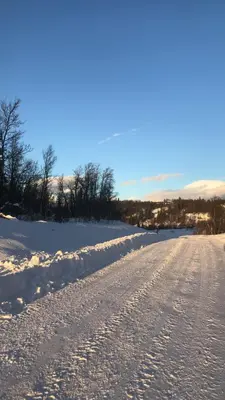 a snow covered road with footprints in the snow at Cabin in the Mountain, with Solar Energy in Slidre