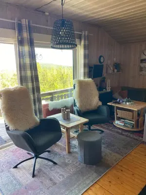 a living room with two chairs and a table at Cabin in the Mountain, with Solar Energy in Slidre