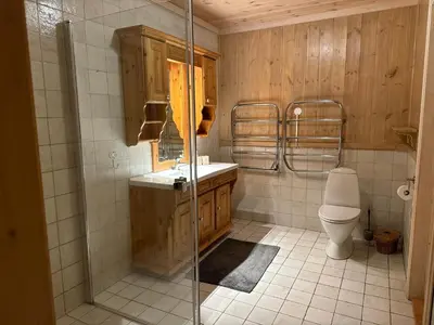 a bathroom with a toilet and a glass shower at Bjødnabakkens historie in Beitostøl