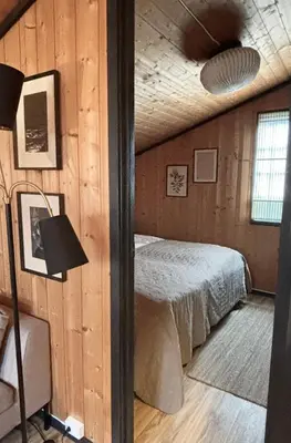 a bedroom with a bed in a wooden wall at Hytte nær Ål in Vass