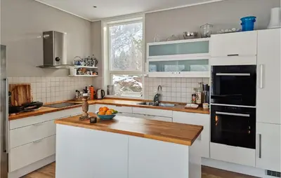 a kitchen with white cabinets and a wooden counter top at Gorgeous Home In Revsnes With Wifi in Refsnes