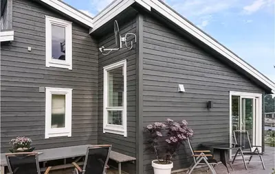 a black house with a table and chairs outside at Gorgeous Home In Revsnes With Wifi in Refsnes