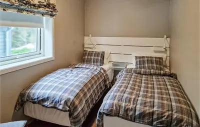 two beds in a room with a window at Gorgeous Home In Revsnes With Wifi in Refsnes