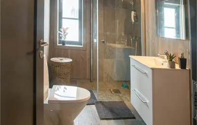 a bathroom with a toilet and a shower and a sink at 4 Bedroom Lovely Home In Østby in Østby
