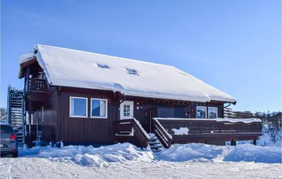 a log cabin with snow on the side of it at Hovden Alpin Apartments in Hovden