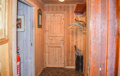 a room with a wooden door and a hallway at Cozy Home In Tuddal With Kitchen in Tuddal