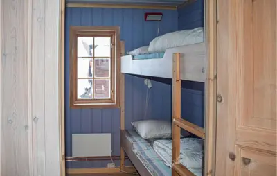 a room with three bunk beds and a window at Cozy Home In Tuddal With Kitchen in Tuddal