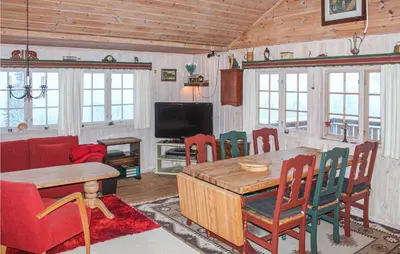 a living room with a table and chairs and a tv at Cozy Home In Tuddal With Kitchen in Tuddal