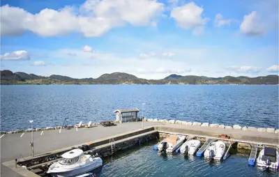 a dock with boats docked on a large body of water at 4 Bedroom Lovely Home In Vikebygd in Vikebygd