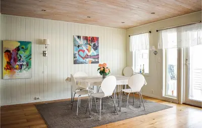 a dining room with a table and white chairs at 4 Bedroom Lovely Home In Vikebygd in Vikebygd