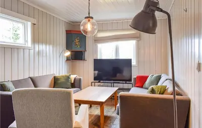 a living room with a couch and a table at Nice Home In Sjusjoen in Sjusjøen