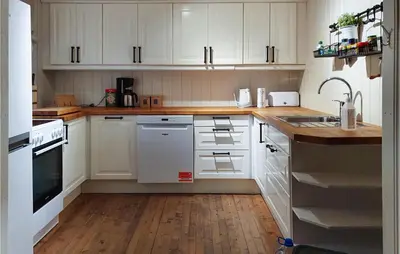 a white kitchen with wooden floors and white cabinets at Nice Home In Sjusjoen in Sjusjøen