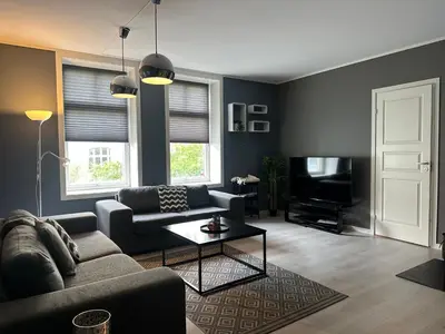 a living room with a couch and a tv at Ålesund City Center - Modern 80-m2 flat with 3 bedrooms in Ålesund