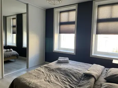 a bedroom with blue walls and a bed with a mirror at Ålesund City Center - Modern 80-m2 flat with 3 bedrooms in Ålesund