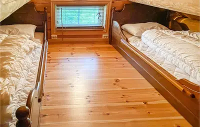 two beds in a room with a wooden floor at Beautiful Home In Sjusjoen in Sjusjøen