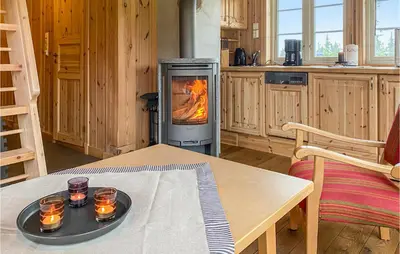 a stove in a kitchen with a table with candles on it at Beautiful Home In Sjusjoen in Sjusjøen