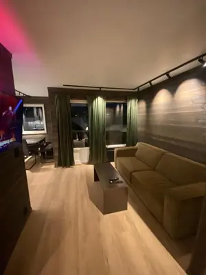 a living room with a couch and a tv at Brobygget Mølla 101 in Kyrkjebøen