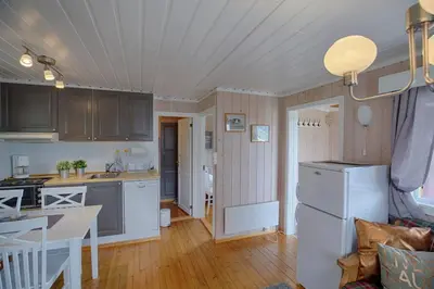 a kitchen and living room with a white refrigerator at Kvetos fjellgårdsutsikt in Beitostøl