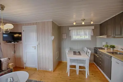 a kitchen with a table and a table and chairs at Kvetos fjellgårdsutsikt in Beitostøl