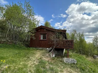 a small wooden cabin in a field of grass at Kvetos fjellhytte in Beitostøl