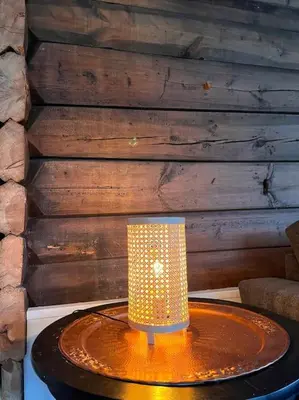 a lamp on a table in front of a wall at Cozy house in Eidfjord in Eidfjord