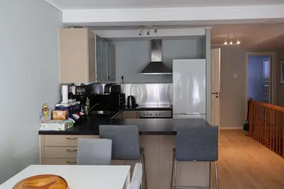 a kitchen with a counter and two chairs in it at Dinbnb Apartments I Charming 3-Bedroom in the Heart of the City in Bergen