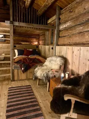a room with a bed in a wooden cabin at Sauefjøset - Idyllisk gardstun fra 1800-tallet in Skjåk