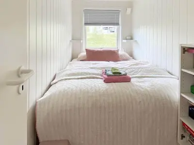 a small bedroom with a bed with a window at 6 person holiday home in Åsenfjord-By Traum in Hopla