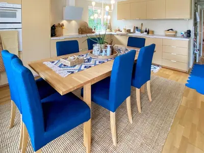a dining room with a wooden table and blue chairs at 6 person holiday home in Åsenfjord-By Traum in Hopla