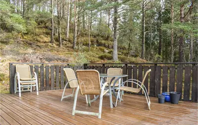 a table and chairs on a wooden deck at Stunning Home In Førde I Hordaland in Lier