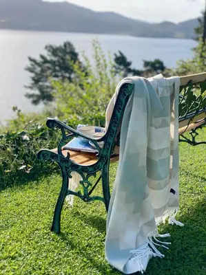 a bench with a blanket on it sitting on the grass at Villa Arboretet - Seaside villa with private pool & infrared sauna in the heart of Arboretet, Bergen in Bergen
