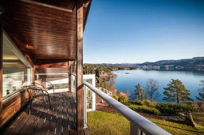 a balcony of a house with a view of a lake at Villa Arboretet - Seaside villa with private pool & infrared sauna in the heart of Arboretet, Bergen in Bergen