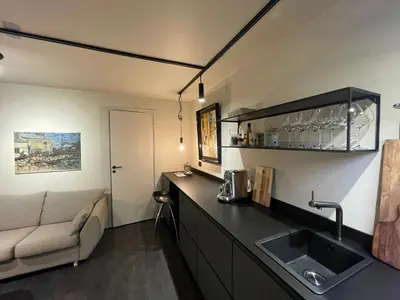 a kitchen with a sink and a couch in a room at Studio Leilighet, nyoppusset in Langevåg