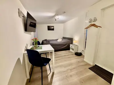 a bedroom with a bed and a desk in a room at Litle cozy apartment in Ålesund in Ålesund