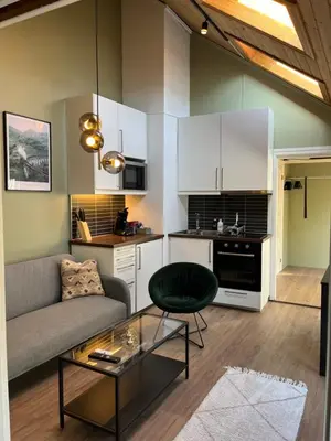 a living room with a couch and a table at Cozy backyard apartment in Trondheim