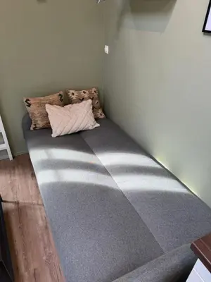 a large bed in a corner of a room at Cozy backyard apartment in Trondheim
