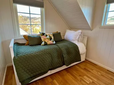 a bedroom with a bed in a room with windows at Hardangerfjord View - luxury fjord-side holiday home in Øystese
