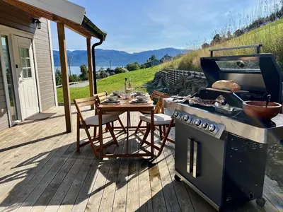 a stove and a table on a deck at Hardangerfjord View - luxury fjord-side holiday home in Øystese