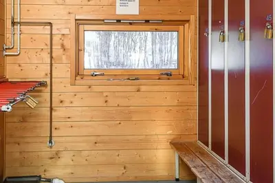 a bathroom with a wooden wall with a window at Friends & Family Apartment at Hafjell Alpinlandsby/Øyer Center in Hafjell