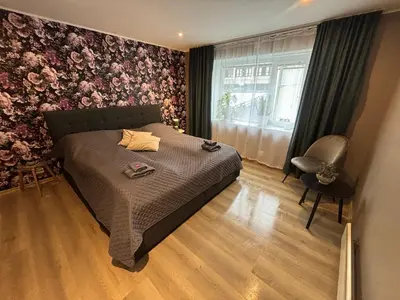 a bedroom with a bed and a chair and a window at 3 rooms apartment in Center in Ålesund