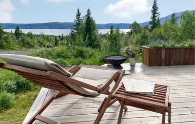 a chair and a table on a wooden deck at Awesome Home In Rauland With Sauna in Rauland