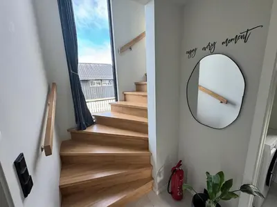 a hallway with stairs with a mirror and a stairwayexit at Chalet Orkanger - Close to Everything, Far from Ordinary in Orkanger