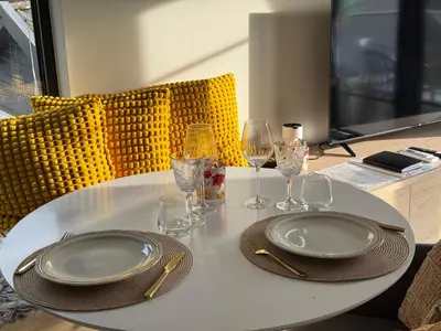 a white table with two plates and wine glasses on it at Chalet Orkanger - Close to Everything, Far from Ordinary in Orkanger