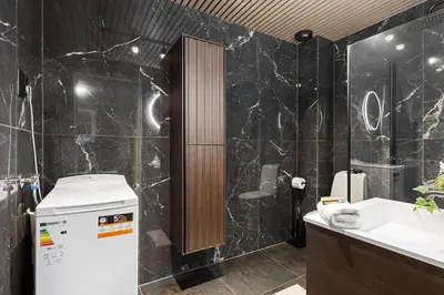 a bathroom with black marble walls and a sink at Apartments Bergen free parking in Bergen