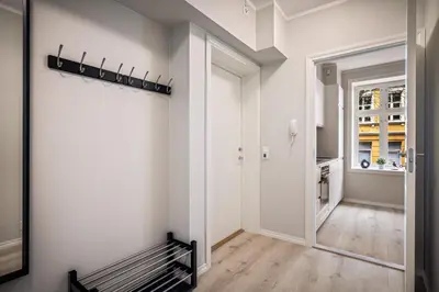 a hallway with a bench in a room with white walls at Meltzers Apartments in Bergen