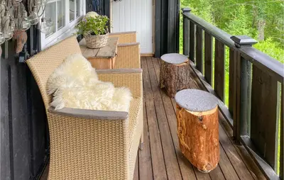 a porch with two benches and a table and some logs at 3 Bedroom Gorgeous Home In Molde in Molde