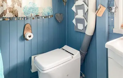 a blue bathroom with a toilet and a sink at 3 Bedroom Gorgeous Home In Molde in Molde