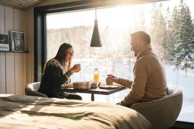 a man and woman sitting at a table in front of a window at Ådalsvollen Retreat in Verdal