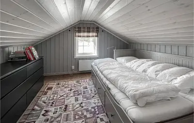 a room with a row of beds in a attic at Amazing Home In Sjusjøen With Sauna in Sjusjøen