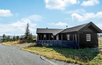 a small house sitting on the side of a road at Amazing Home In Sjusjøen With Sauna in Sjusjøen